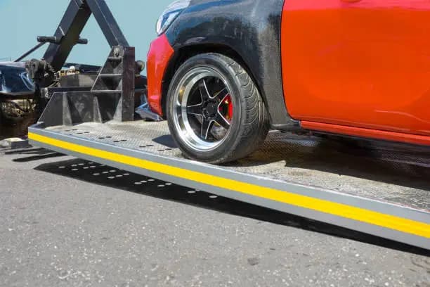 Electric vehicle positioned on a flatbed towing platform