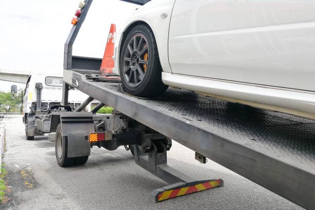 Car being loaded onto a flatbed towing truck
