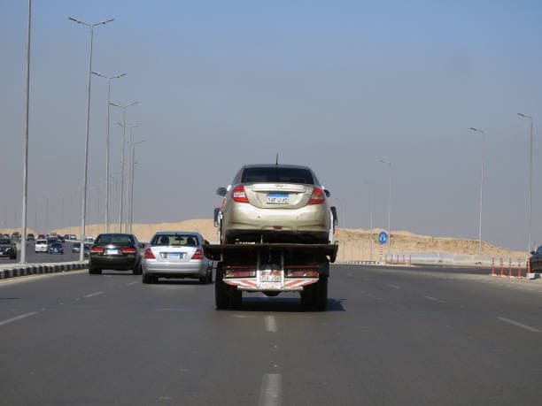 Car being transported by a tow truck on a highway